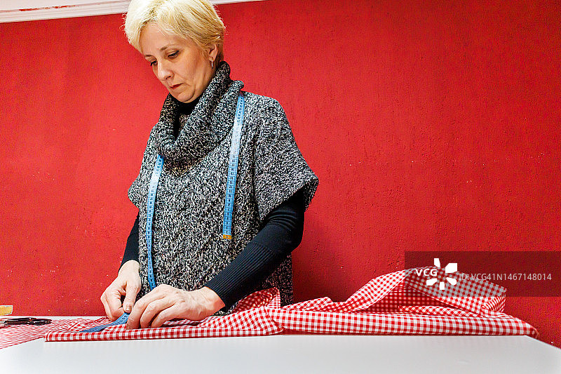 女裁缝在工作室用剪刀和尺子准备面料图片素材