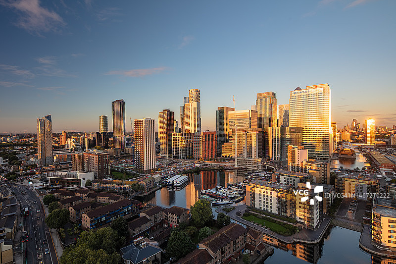 伦敦金丝雀码头和伍德码头商业区天际线的日出，前景是布莱克沃尔盆地码头，英国伦敦，2021年图片素材