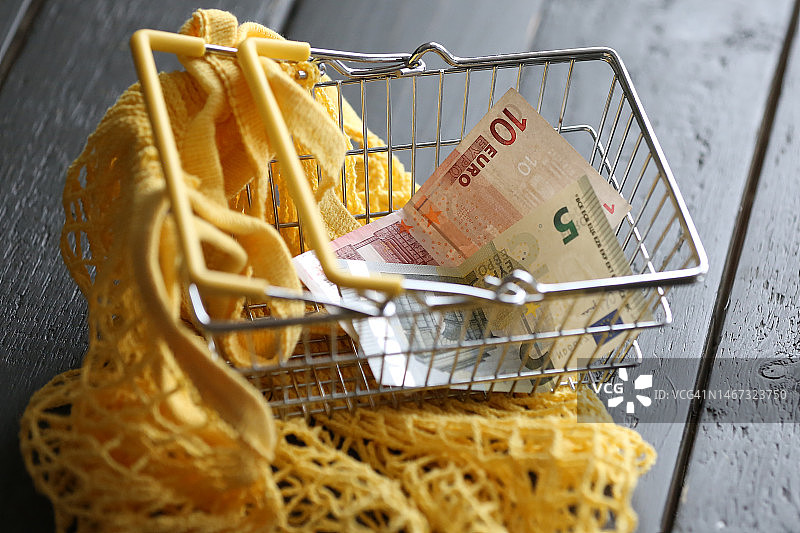 黄色环保袋空购物车，内含两张欧元纸币图片素材