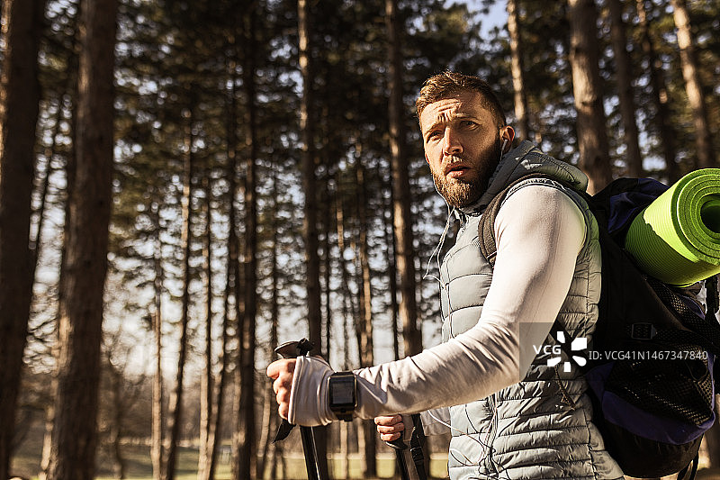 年轻男子背着背包在森林里行走图片素材