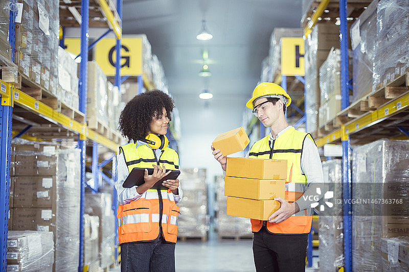 年轻男女仓库工人帮助将货物抬起，以便将货物存储在仓库内，并将货物运送到目的地图片素材
