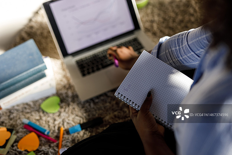 学生分析笔记本电脑上的图表并记笔记图片素材