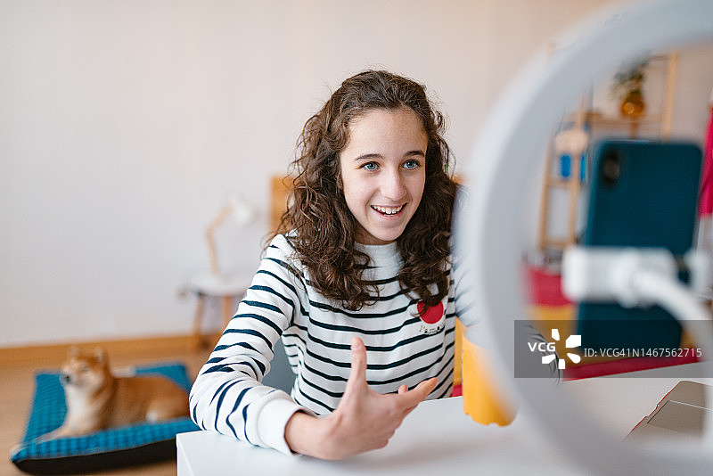 坐在房间里录制社交网络视频的少女正面图图片素材