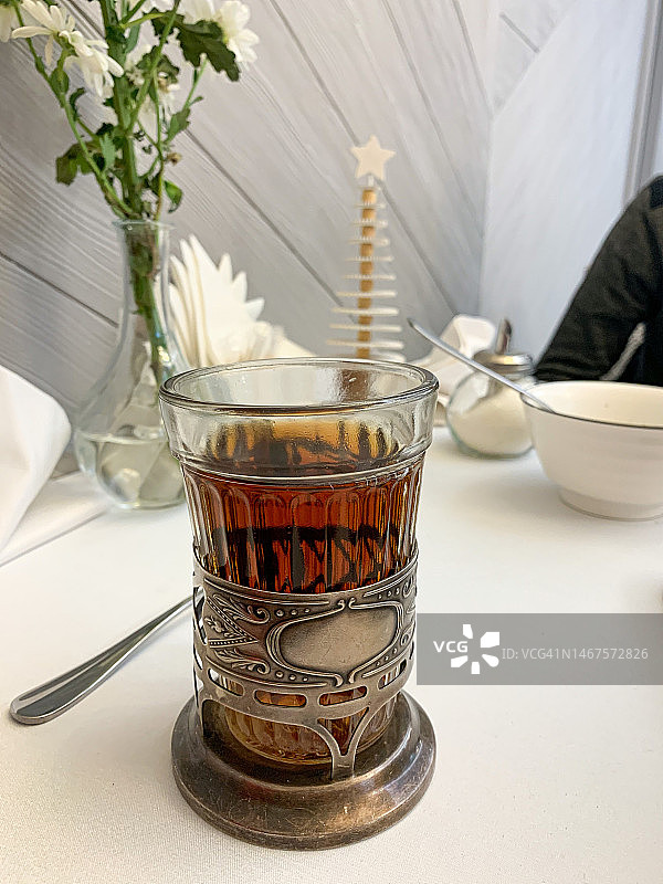 透明玻璃杯中的红茶，带铁把手。俄式多面玻璃杯中的茶图片素材