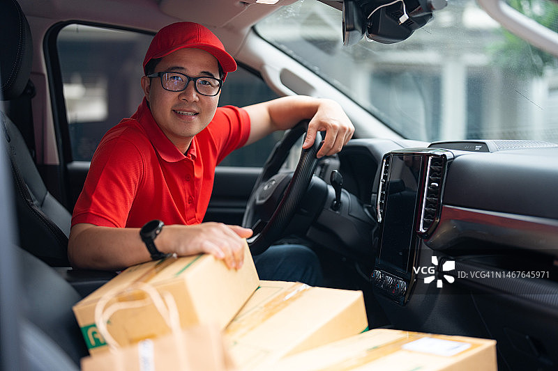 在快递货车中工作的快乐亚洲青年图片素材