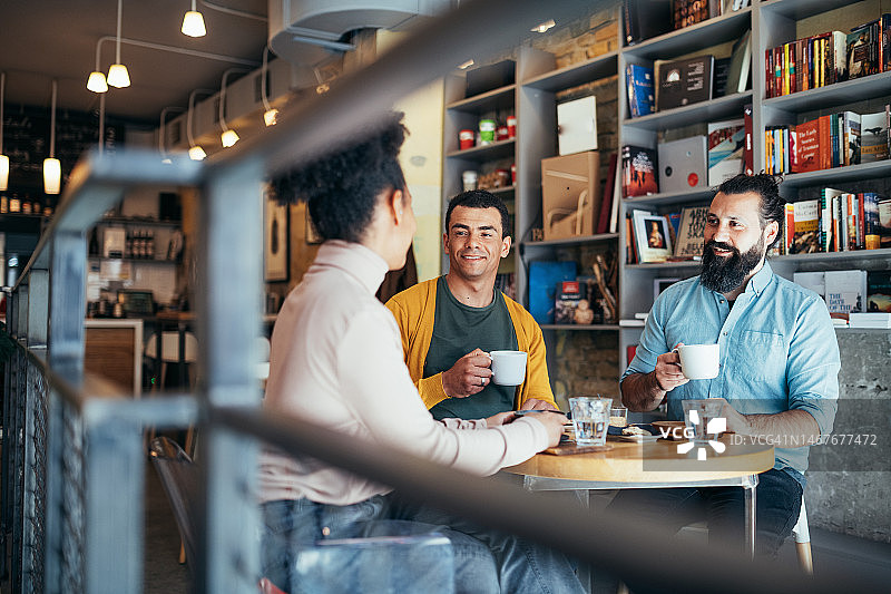 办公室外的团队合作，同事们在下班后坐在现代咖啡馆里图片素材