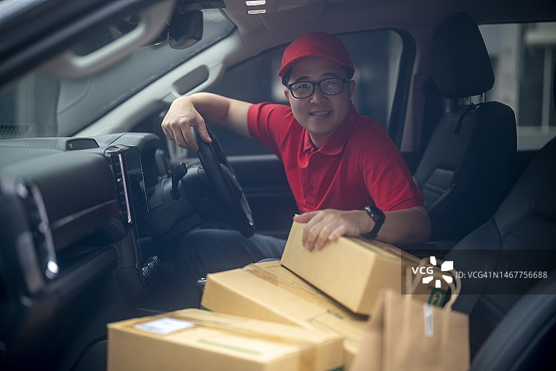 年轻邮递员坐在车里送货图片素材
