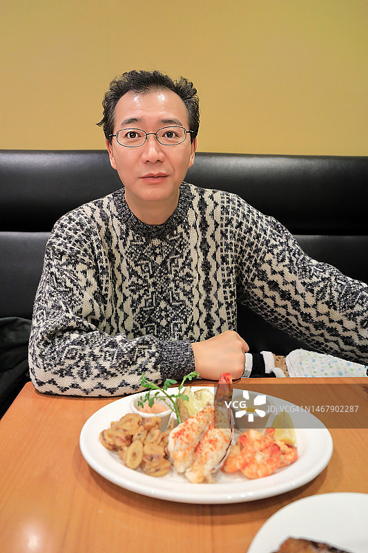 在餐厅里照顾在沙发椅上睡觉的孩子的父亲图片素材