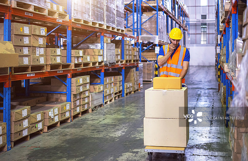 仓库中工人推着手推车图片素材