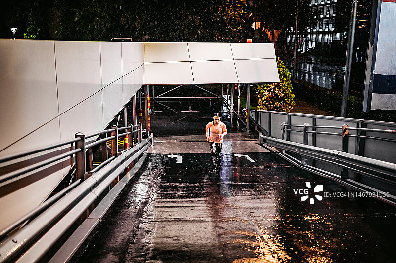 在雨夜户外慢跑的年轻女人图片素材