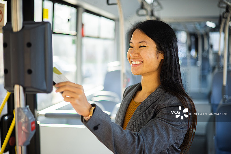购买公交车票的快乐亚洲女性肖像图片素材