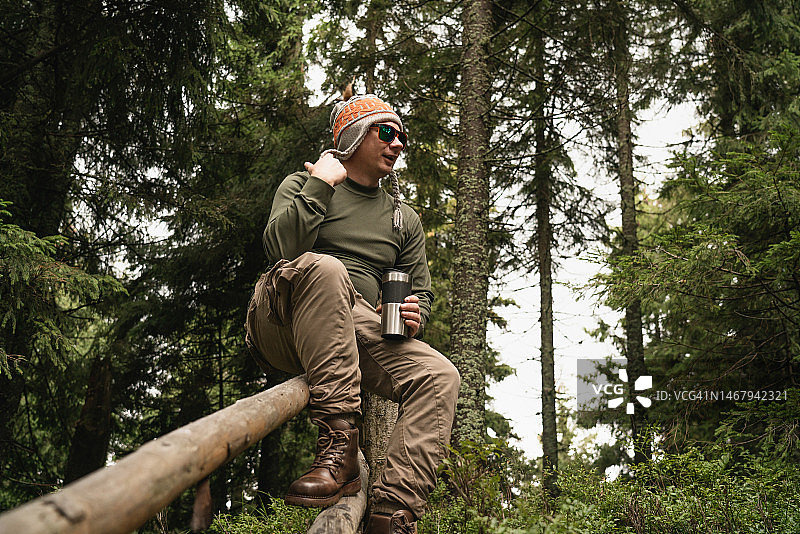 在栅栏旁休息的男人图片素材