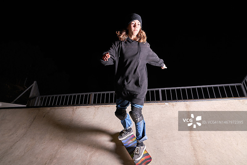 夜晚在滑板公园玩滑板的年轻女孩图片素材