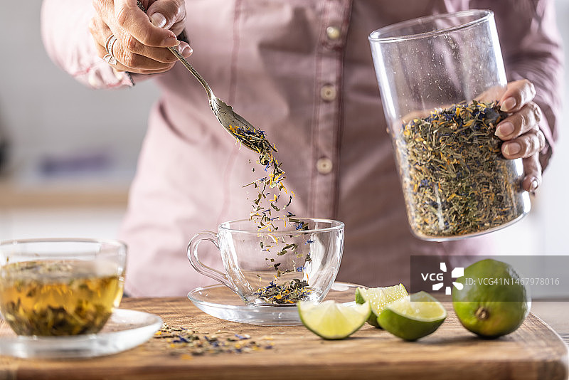 女人将茶叶倒入玻璃杯中图片素材