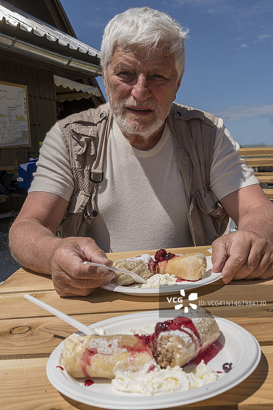 老年男人在山间小屋户外用餐图片素材