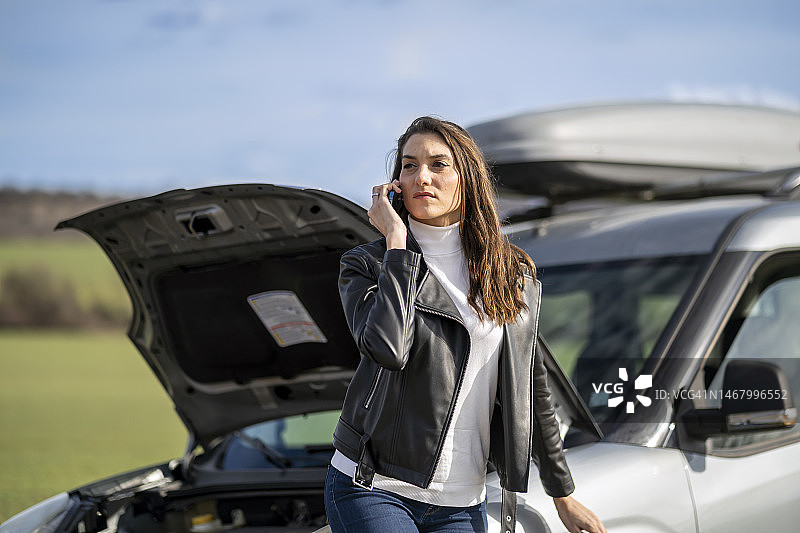 年轻女人和抛锚的汽车图片素材