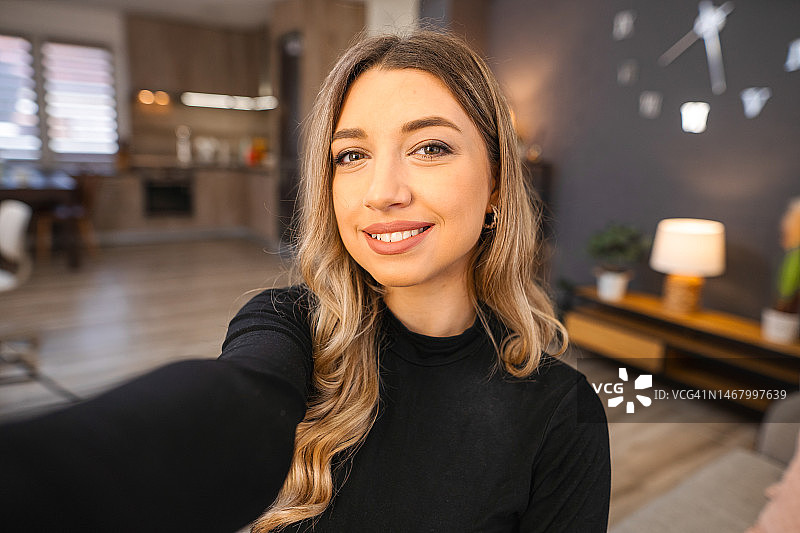 在家自拍的笑容年轻女子图片素材