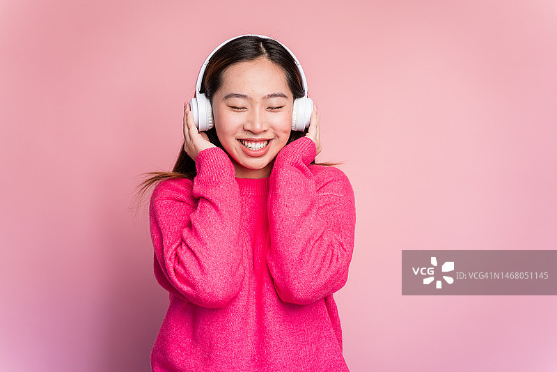 快乐的亚洲女人在听音乐图片素材