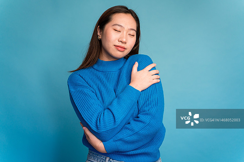 微笑的亚洲女性穿着毛衣看着镜头图片素材