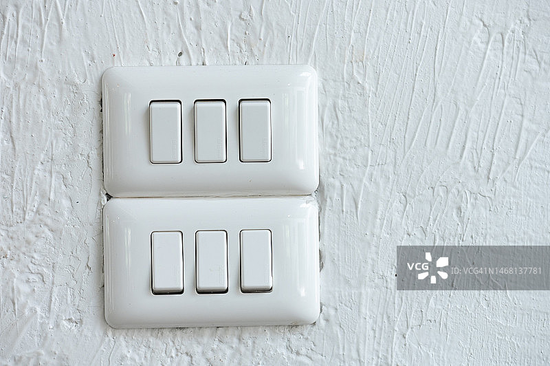白色墙壁上的灯开关特写图片素材
