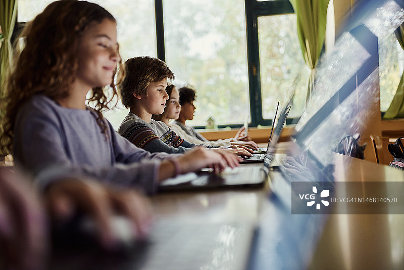 一群小学生在学校的课堂上使用笔记本电脑图片素材