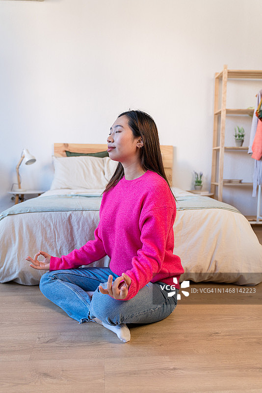 年轻女人坐在地板上冥想图片素材