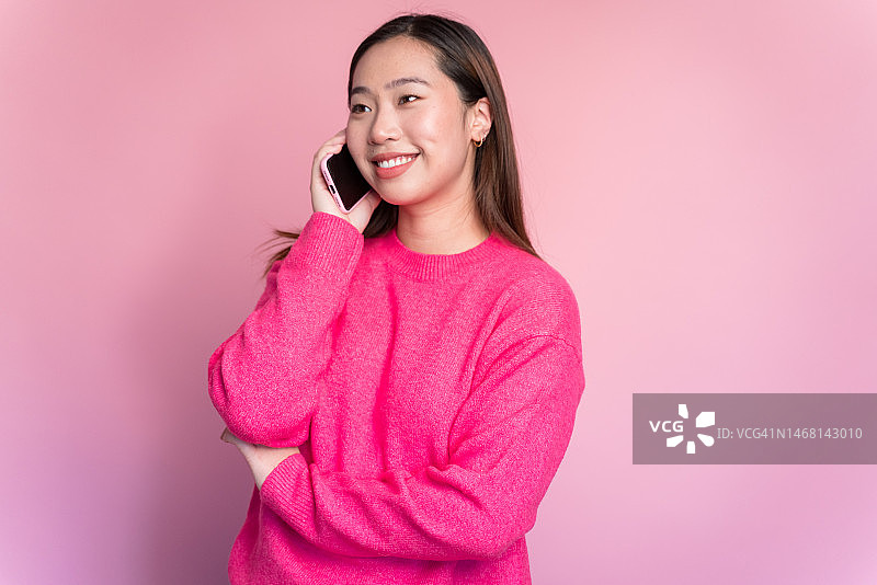 微笑的女人用智能手机讲话图片素材