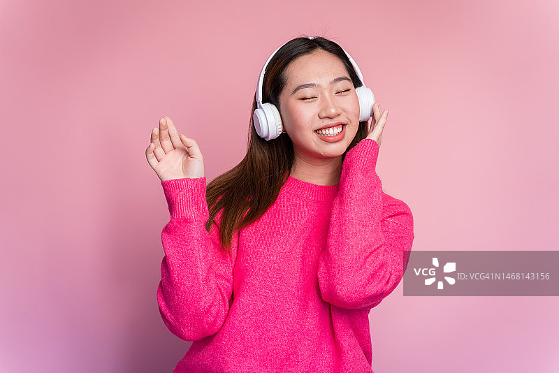 快乐的亚洲女人在听音乐图片素材