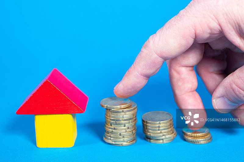 手指触摸由大到小的硬币塔图片素材