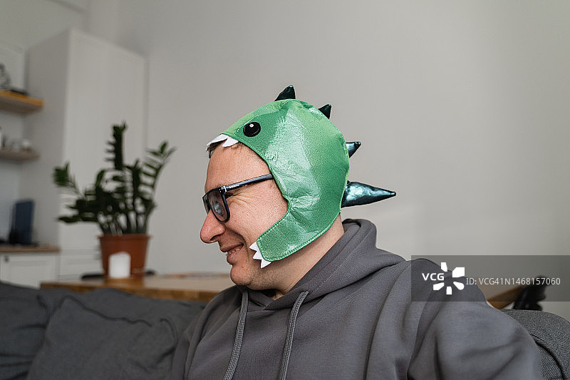戴恐龙派对头套的中年男人图片素材