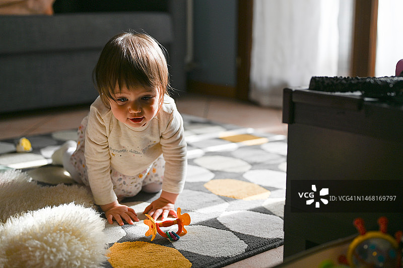 在家在地板上玩耍的幼儿女孩图片素材