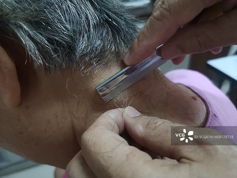 用剃刀修剪颈部末端的头发图片素材