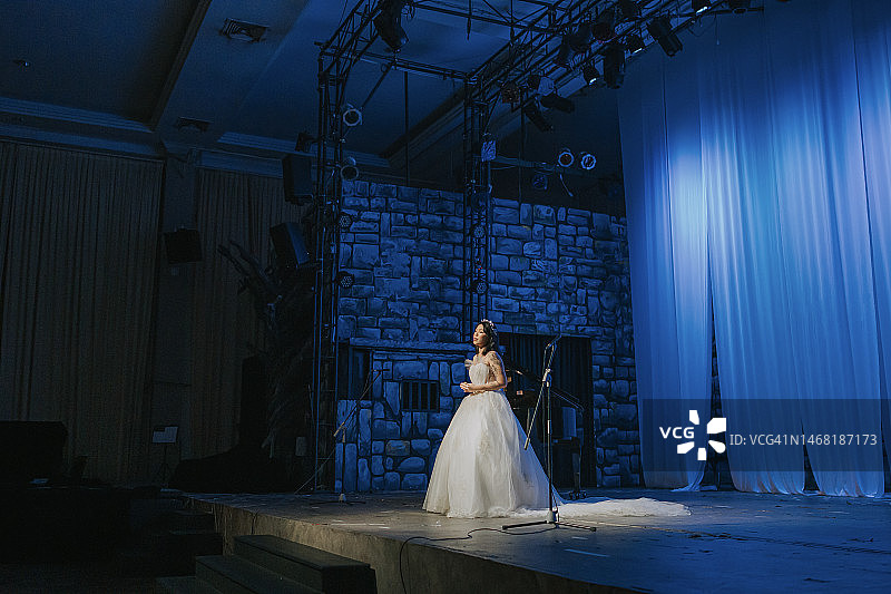 年轻的中国女歌唱家在舞台上独唱图片素材