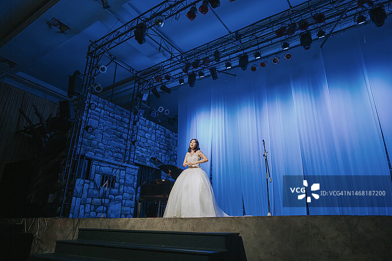 年轻的中国女歌唱家在舞台上独唱图片素材
