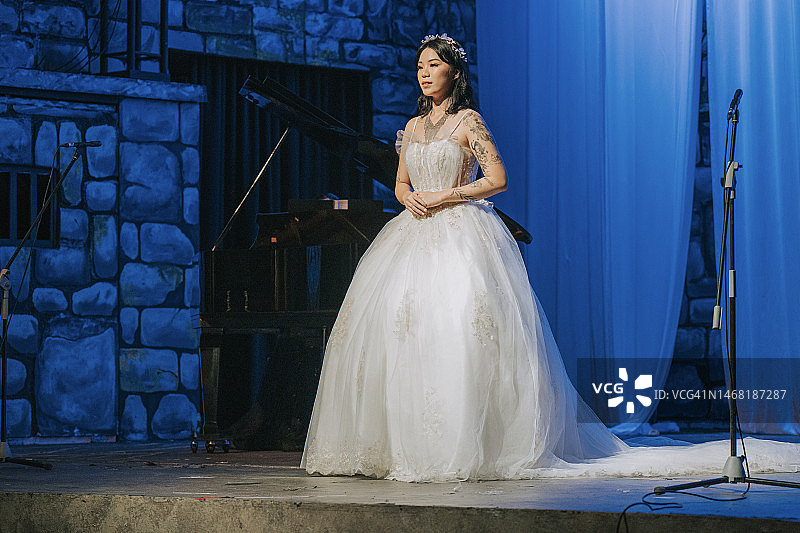 年轻的中国女歌唱家在舞台上独唱图片素材