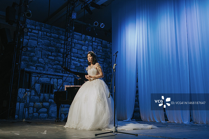 年轻的中国女歌唱家在舞台上独唱图片素材