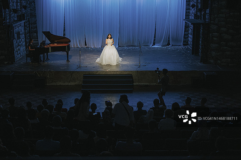 中国青年女歌唱家与钢琴家在舞台上独唱图片素材