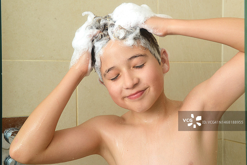 男孩在淋浴时洗头图片素材
