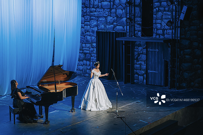 中国女歌唱家与钢琴家在舞台上表演图片素材