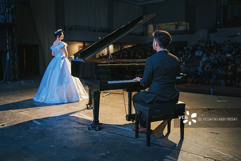 中国钢琴家与女歌唱家在舞台上表演图片素材