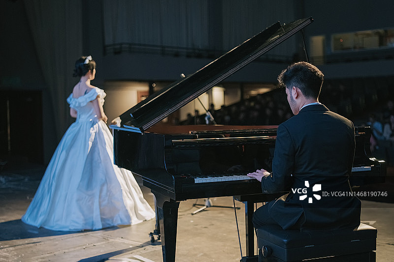 中国钢琴家与女歌唱家在舞台上表演图片素材