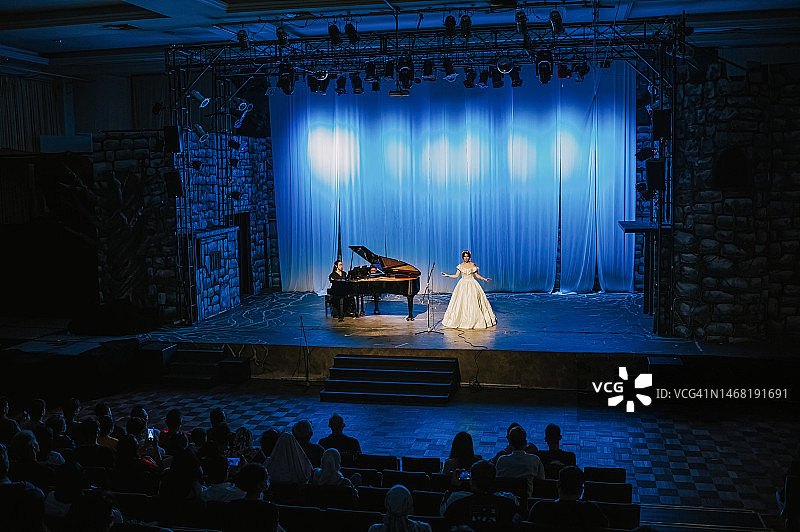 中国女歌唱家与钢琴家在舞台上表演图片素材