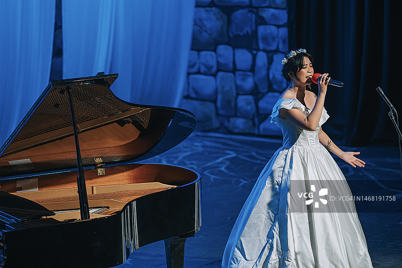 中国青年女歌唱家与钢琴家在舞台上独唱图片素材