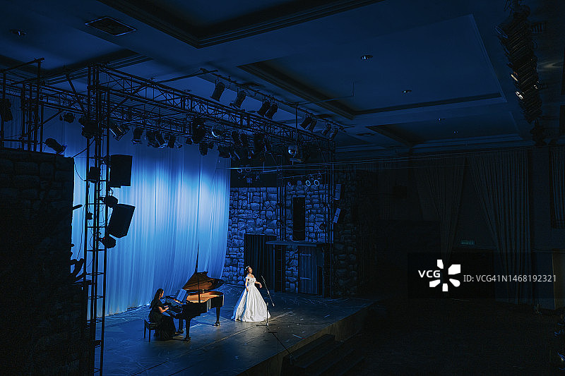 中国女歌唱家与钢琴家在舞台上表演图片素材