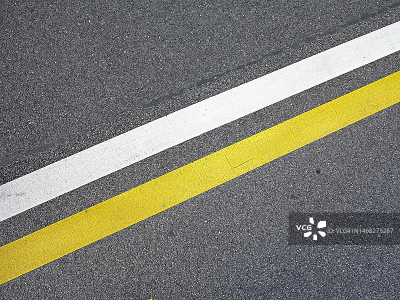 日内瓦街道灰色停机坪上绘制的两条黄色和白色线条图片素材