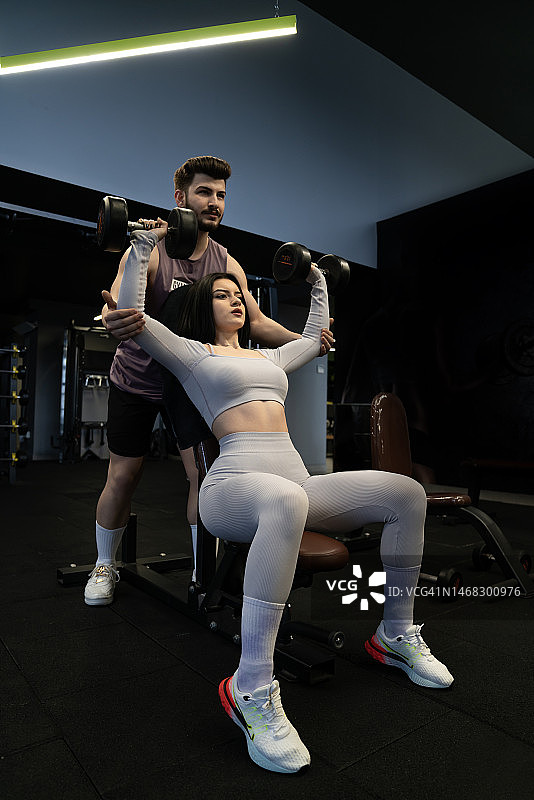 年轻运动情侣在健身房锻炼图片素材