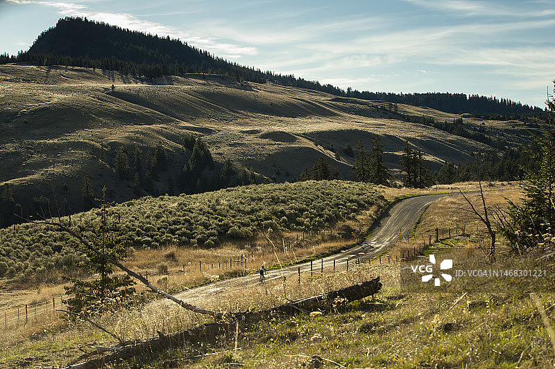 在加拿大不列颠哥伦比亚省坎卢普斯附近风景优美的乡村土路上骑砾石自行车图片素材