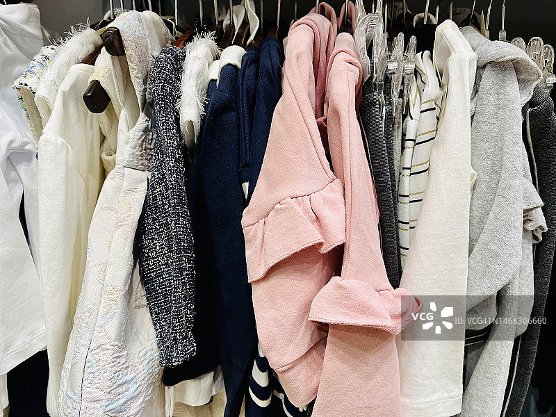 拥挤衣柜里悬挂的各种衣服特写图片素材