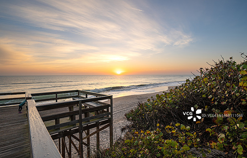 幼儿女孩在佛罗里达梅里特岛国家野生动物保护区琳达海滩欣赏美丽的日出图片素材