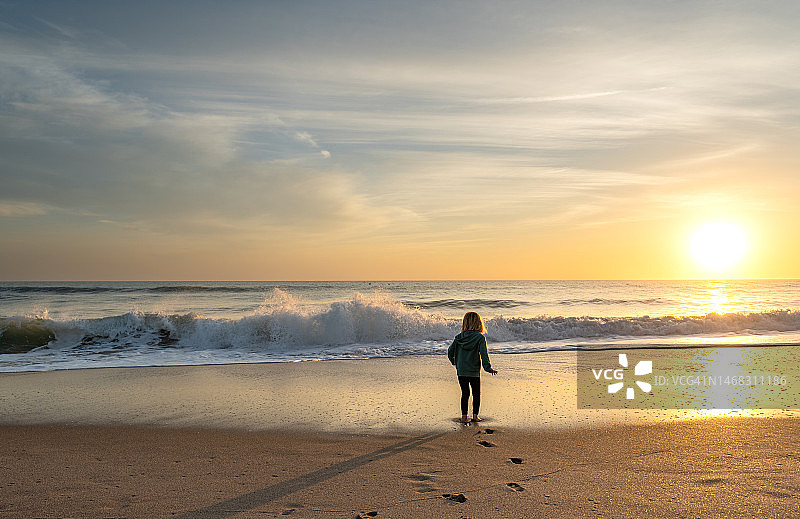 幼儿女孩在佛罗里达梅里特岛国家野生动物保护区琳达海滩欣赏美丽的日出图片素材